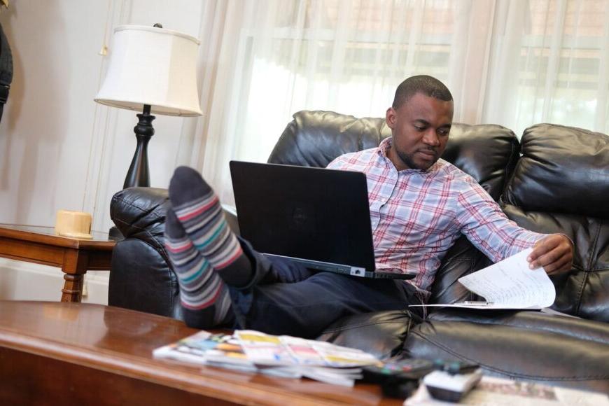 adult learner on sofa with laptop